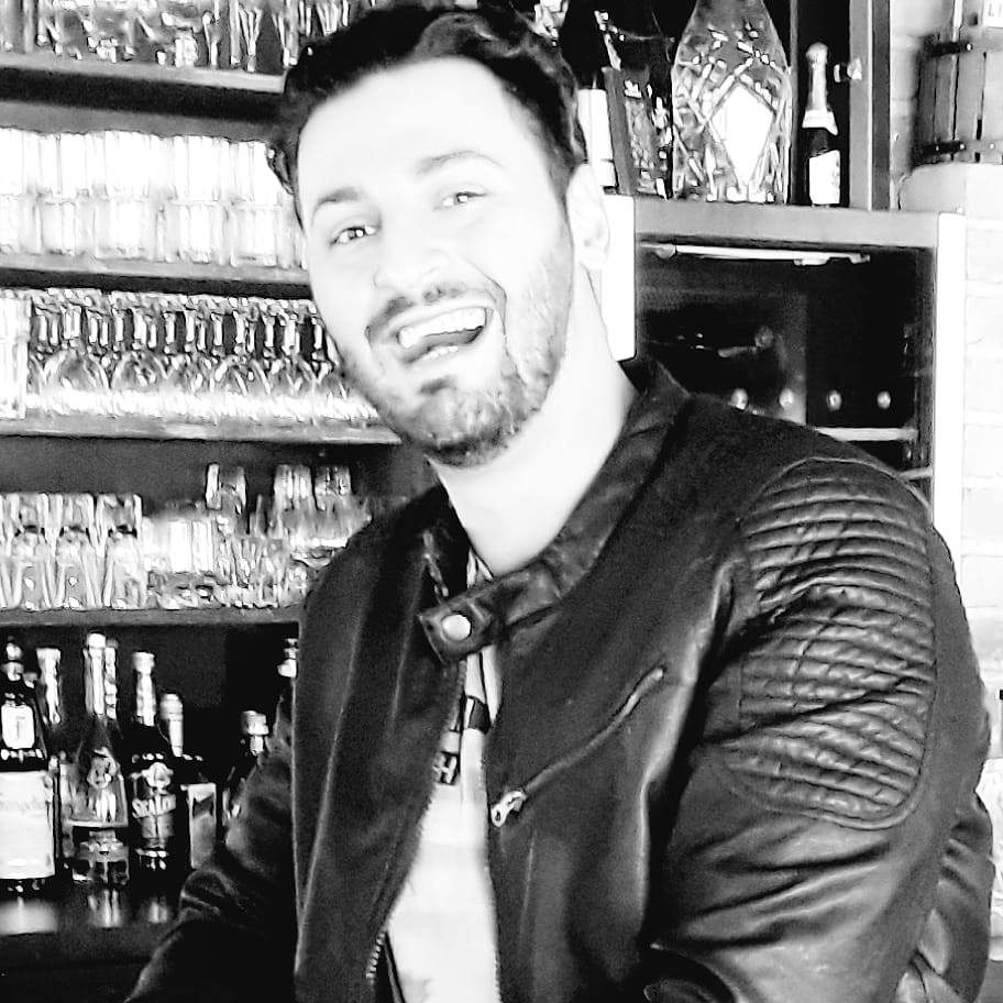 Samuel La Manna sorridente in un locale, scatto informale in bianco e nero